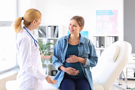Schwangere Frau im Gespräch mit einer Ärztin