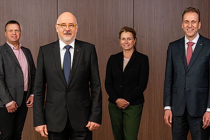 Vier Personen des neuen Präsidiums stehen vor einer braunen Wand.